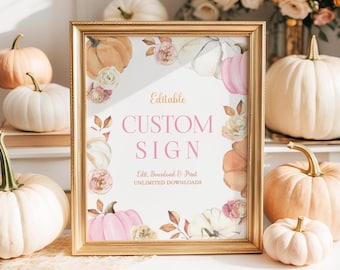 May include: A framed sign with the text "Editable Custom Sign" in pink and gold lettering. The sign is decorated with watercolor pumpkins and flowers in shades of pink, peach, and white. The frame is gold.
