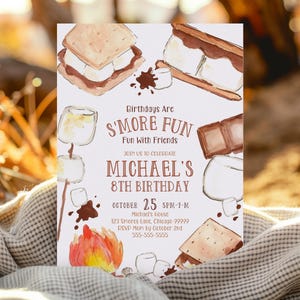 Op de afbeelding: Een witte uitnodigingskaart met aquarel illustraties van s'mores, marshmallows en een kampvuur. De tekst luidt "Birthdays Are S'More Fun" en kondigt Michael's 8e verjaardag aan op 25 oktober.