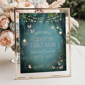May include: A framed sign with a gold border displays a whimsical forest scene with butterflies, fairy lights, and the text "EDITABLE CUSTOM TABLE SIGN". The sign is surrounded by flowers.