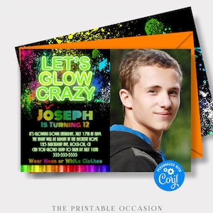 Glow birthday invitation for boys featuring bright neon green lettering, colorful paint splatters and a photo area for the birthday boy. The black background is accented with vivid green, yellow, blue and orange for a glow in the dark party look. The invitation is displayed at an angle with an orange envelope behind it. A round blue badge highlights the cool glow party theme.