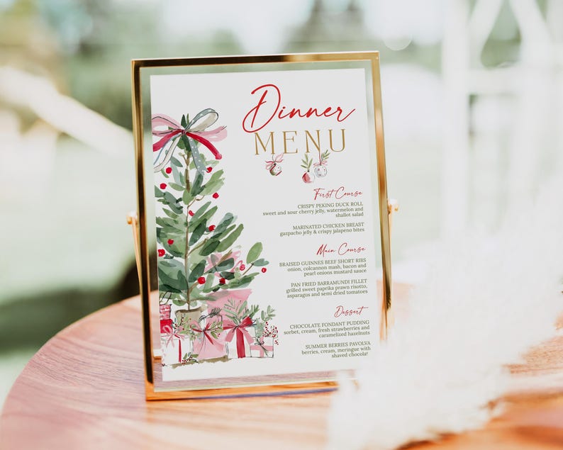 May include: A vertical dinner menu card in a gold metal frame featuring a watercolor illustration of a Christmas tree with red bows and gifts. The text reads Dinner Menu, First Course, Main Course, and Dessert with various food items listed.