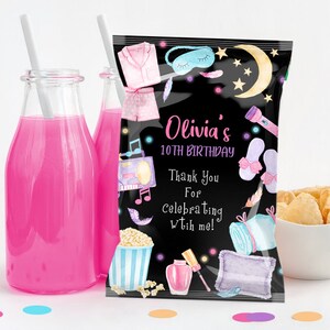 May include: Black and white party favor bag with a sleepover theme. The bag features a pink pajamas, a sleep mask, a flashlight, slippers, popcorn, nail polish, and a pillow. The text on the bag reads "Olivia's 10th Birthday Thank You For Celebrating With Me!"
