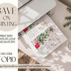 Print setup mockup showing two red bow Christmas party invitations emerging from a home printer. The printable holiday invitation design includes a watercolor Christmas tree, gift boxes, and gold lettering, surrounded by festive décor and evergreen branches for an elegant winter aesthetic.
