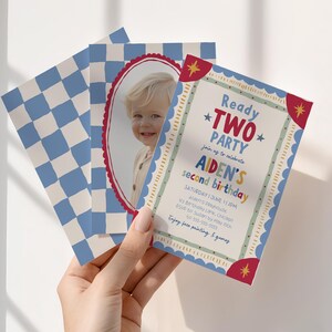 May include: A rectangular birthday invitation card featuring a blue and white checkered pattern, a photograph of a child inside a red scalloped oval frame, and text reading Ready TWO PARTY, Aiden's second birthday, with event details and star icons.