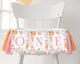 May include: A pink and white high chair banner with the word "ONE" in pink letters. The banner has a fall theme with pumpkins, leaves, and flowers.