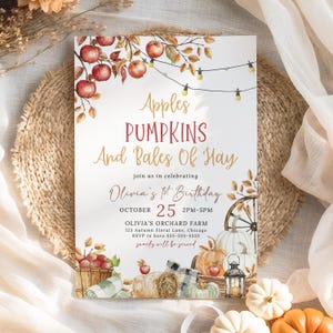 Könnte beinhalten: Eine Einladungskarte mit dem Text "Apples, Pumpkins, And Bales Of Hay" für Olivias 1. Geburtstag. Das Design zeigt Illustrationen von Äpfeln, Kürbissen, Heuballen und einem dekorativen Rad. Das Datum ist der 25. Oktober, 14-17 Uhr.