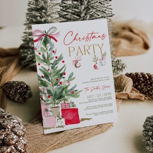 Editable Christmas invitation template with watercolor red bow and ornaments, styled at an angle on neutral linen with frosted pinecones and greenery. The realistic lighting and texture emphasize the quality of the printed card, showcasing a warm natural holiday setting ideal for family gatherings or work parties.