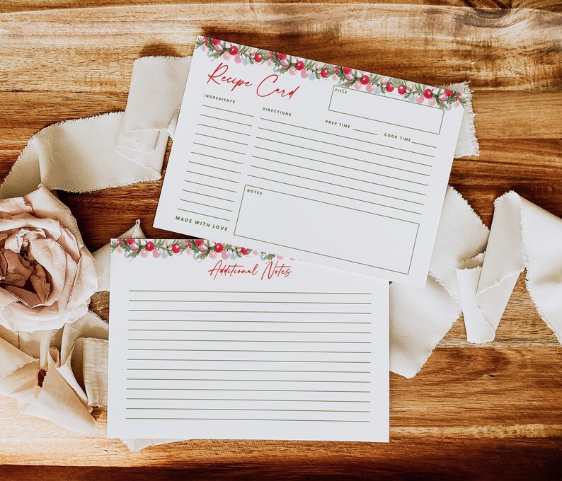 May include: Two white rectangular recipe cards with a festive garland of red berries and green leaves at the top. The top card features the text Recipe Card, Ingredients, Directions, Title, Prep Time, Cook Time, Notes, and Made With Love. The bottom card says Additional Notes.