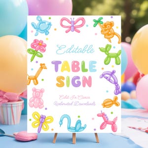 May include: A white sign on a wooden easel with the words "TABLE SIGN" in pastel colors. The sign is decorated with balloon animals, including a giraffe, dog, and butterfly. The text "Editable" and "Edit in Canva" are also present.