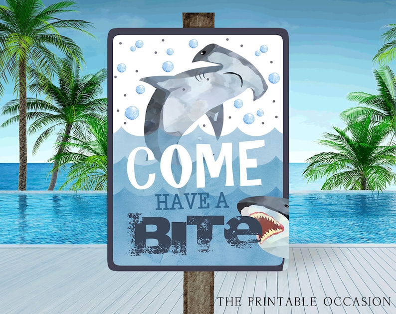 May include: A blue and white sign with a shark and hammerhead shark illustration. The sign says "Come Have a Bite".