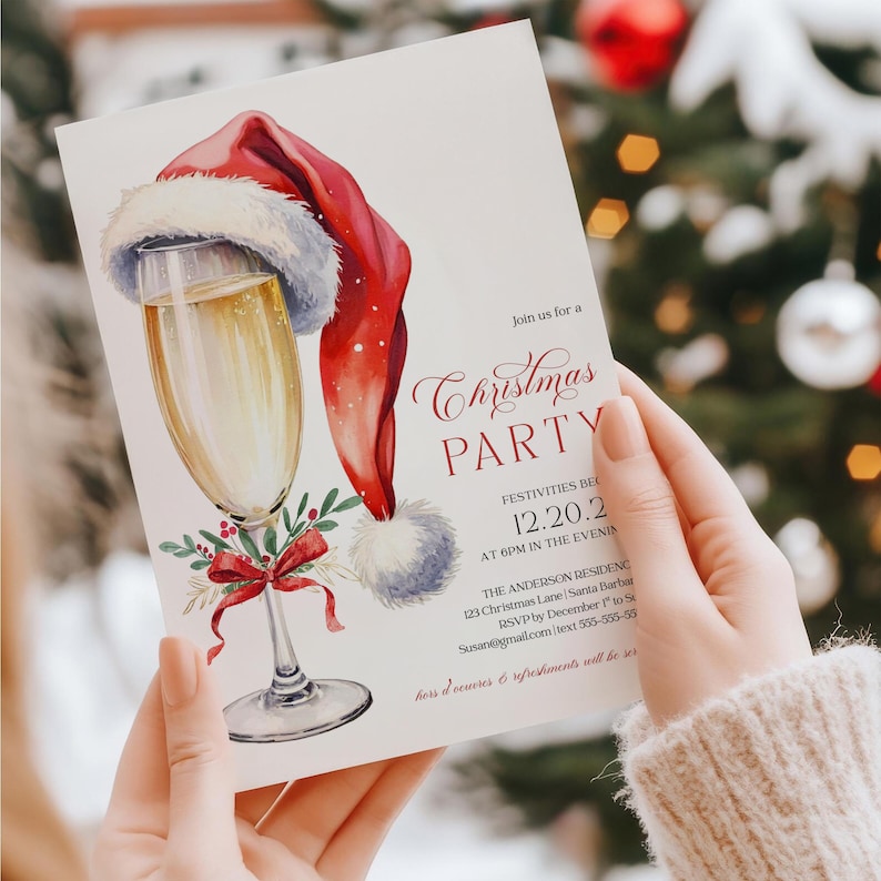 Editable Christmas invitation with a champagne glass topped with Santa hat and red bow, designed for festive cocktail parties and Friendsmas get-togethers. The template is perfect for holiday gatherings, office events, or adult Christmas celebrations. Shown outdoors with a blurred tree background, the mockup gives a natural, wintry vibe that complements the holiday theme.