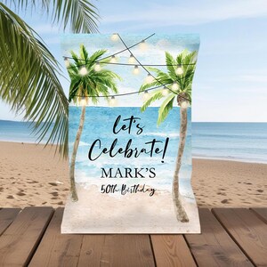May include: A white chip bag with a beach scene and palm trees. The text on the bag reads "Let's Celebrate! Mark's 50th Birthday".