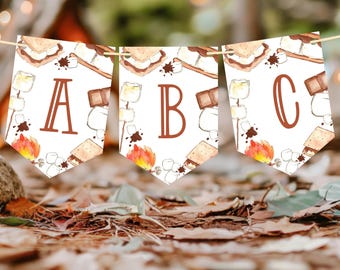 May include: A banner with three triangular pennants, each with a letter: A, B, and C. The pennants feature watercolour illustrations of s'mores, marshmallows, chocolate, and a campfire. The banner is strung on a thin, natural-coloured string.