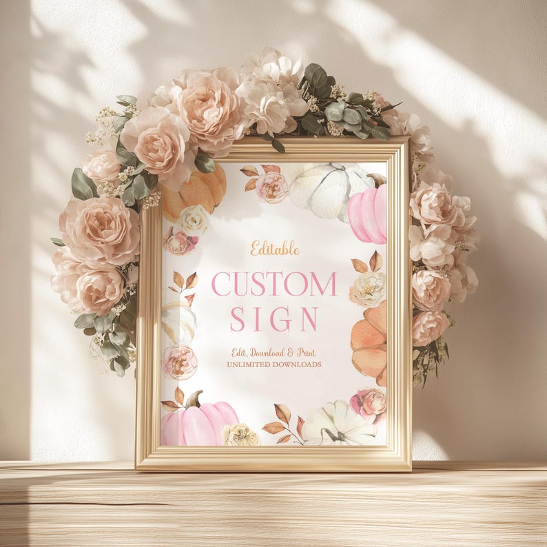 Custom pumpkin birthday party sign framed in gold and encircled by a full wreath of neutral and blush florals. Watercolor pumpkins and muted fall leaves give the design a cozy seasonal touch. Styled in soft golden light, creating a rustic and elegant birthday setup ideal for an autumn birthday girl.
