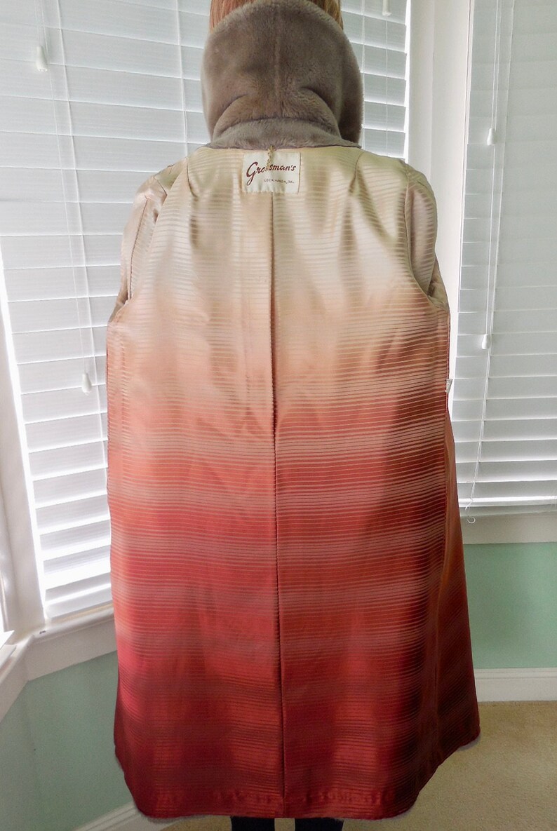 May include: A brown fur coat with a satin lining that has a gradient from cream to red. The coat has a label that says "Greisman's" on the back.