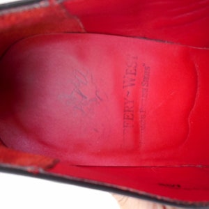 Puede incluir: Primer plano del interior de cuero rojo de un zapato con el texto "Tery-West" y "West-Tex Shoes" impreso en la plantilla.