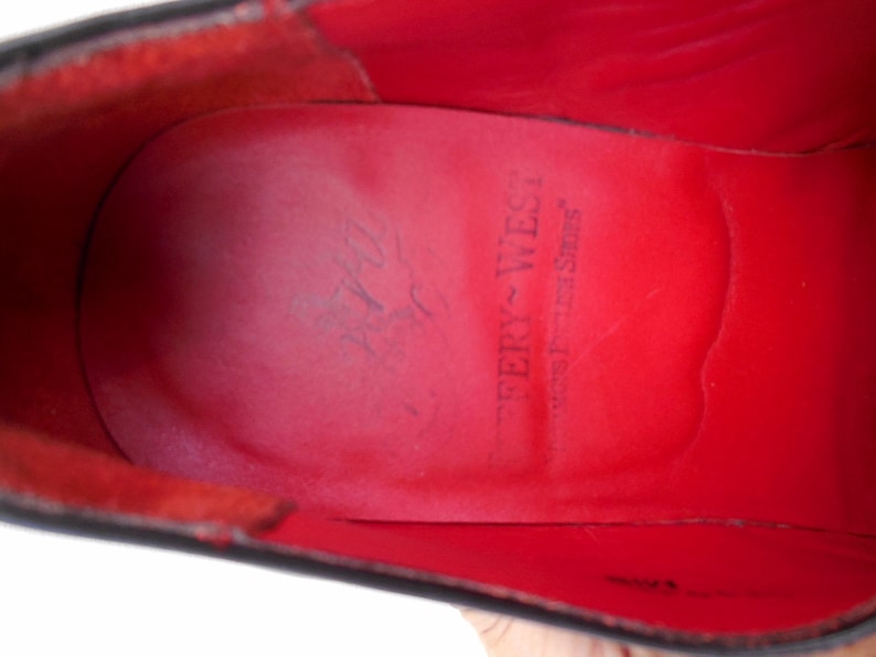 Puede incluir: Primer plano del interior de cuero rojo de un zapato con el texto "Tery-West" y "West-Tex Shoes" impreso en la plantilla.