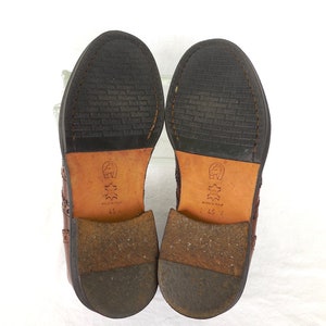 Pode incluir: Um par de sapatos de couro marrom com design brogue. Os sapatos t&ecirc;m uma sola de couro preto e s&atilde;o tamanho 45. Os sapatos s&atilde;o feitos na It&aacute;lia.