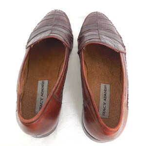 K&ouml;nnte beinhalten: Ein Paar braune Lederschuhe mit Kroko-Pr&auml;gung. Die Loafer sind slip-on und tragen den Markennamen "Stacy Adams" auf der Innensohle.