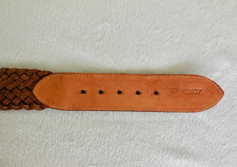 May include: Brown leather belt with a braided strap and five belt loops. The belt has the number "30 42407" stamped on the back.