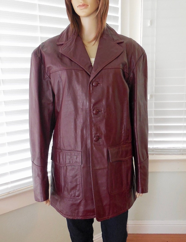 May include: A burgundy leather jacket with a button-up front and two flap pockets.