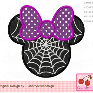 May include: A Halloween-themed design featuring a black mouse head shape with a white spiderweb and a purple bow with white polka dots. The design includes the text "Original Design by Cherrystitchdesign".