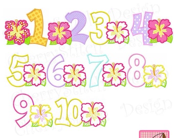 May include: A set of ten colorful embroidered numbers with hibiscus flowers. The numbers are in a variety of colors, including yellow, pink, purple, blue, and green. The hibiscus flowers are in shades of pink, yellow, and white.