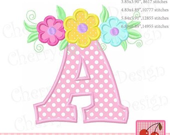 May include: A pink letter "A" with white polka dots, adorned with colorful flowers and green leaves. The design includes the text "Original Design by Cherrystitchdesign" and a cherry logo. The design is for embroidery.
