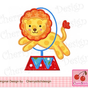 May include: A cartoon lion jumping through a blue hoop, with a red and blue circus base. The lion is yellow with orange accents and a star-patterned mane. The image includes the text "Original Design by Cherrystitchdesign" and a cherry logo.
