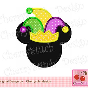 May include: Black Mickey Mouse ears with a colorful jester hat on top. The hat has a yellow crown, green and yellow pointed hat, and purple and white polka dot accents.
