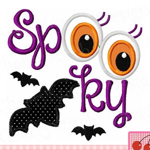 May include: Purple "Spooky" text with two large white eyes with orange pupils and black eyelashes. There are two black bats with white polka dots.