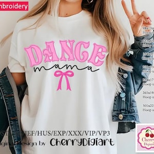 May include: Pink machine embroidery design of the words "Dance Mama" with a pink bow underneath. The design is shown on a white t-shirt.