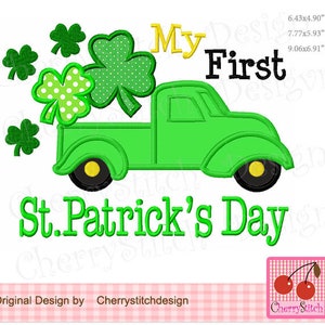 May include: Green truck with a shamrock design carrying a bunch of shamrocks. The truck has yellow wheels and the text "My First St. Patrick's Day" is written below the truck.