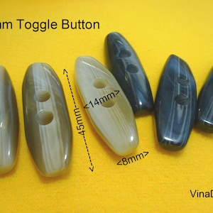 May include: Four toggle buttons, two are white with brown stripes and two are dark blue with light blue stripes. The buttons are 4.5 cm long and 1.4 cm wide. The text "45mm Toggle Button" is visible at the top of the image.