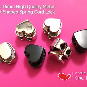 Può includere: Cinque fermagli per cordino in metallo a forma di cuore, in argento e nero. I fermagli misurano 16 mm e hanno un meccanismo a molla.