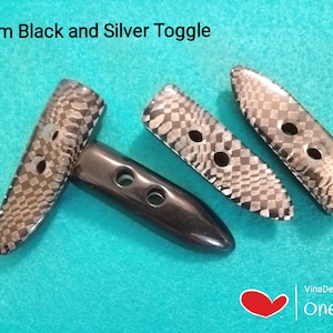 May include: Three 50mm black and silver toggle buttons. Two buttons have a black and silver checkered pattern. One button is solid black.