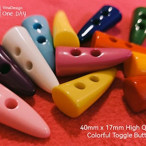 May include: Assortment of colourful plastic toggle buttons in various shapes and sizes. The buttons are 40mm x 17mm and are high quality. VinaDesign One Day.