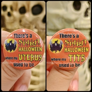 May include: Two round orange buttons with black text and graphics. One says "There's a Spirit Halloween where my Uterus used to be." The other says "There's a Spirit Halloween where my Tits used to be."