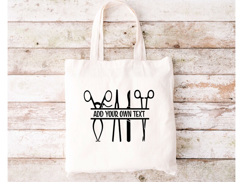 May include: White canvas tote bag with a black design of surgical instruments, including scissors, forceps, and a scalpel. The design includes a banner with the text "ADD YOUR OWN TEXT".