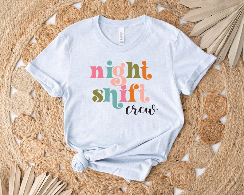 May include: Light blue t-shirt with the text "night shift crew" in colorful retro font.