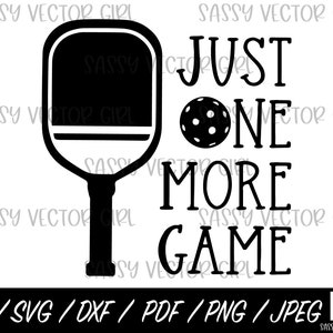 Puede incluir: Dise&ntilde;o gr&aacute;fico en blanco y negro con una pala de pickleball y una pelota con el texto "Just One More Game".