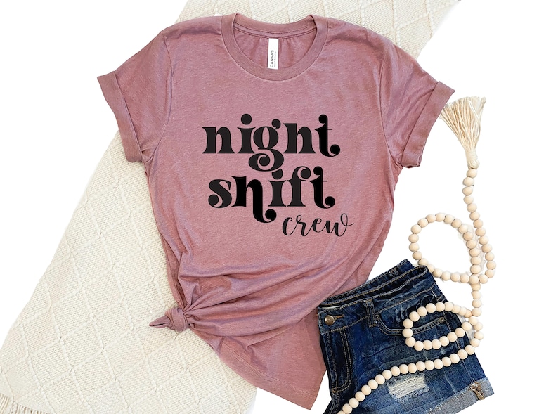 May include: A mauve t-shirt with the text "night shift crew" in black retro-style font.