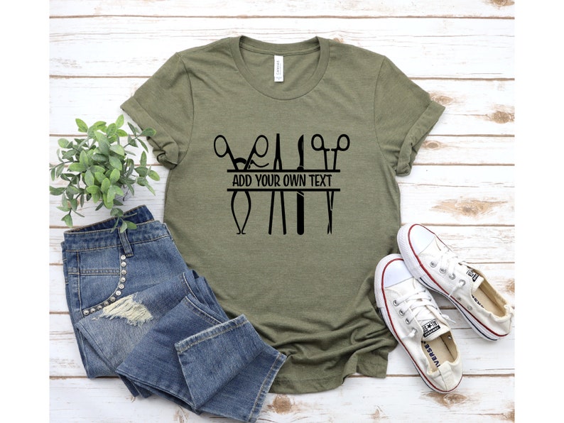 May include: Green t-shirt with a black graphic of surgical instruments and the text "ADD YOUR OWN TEXT".