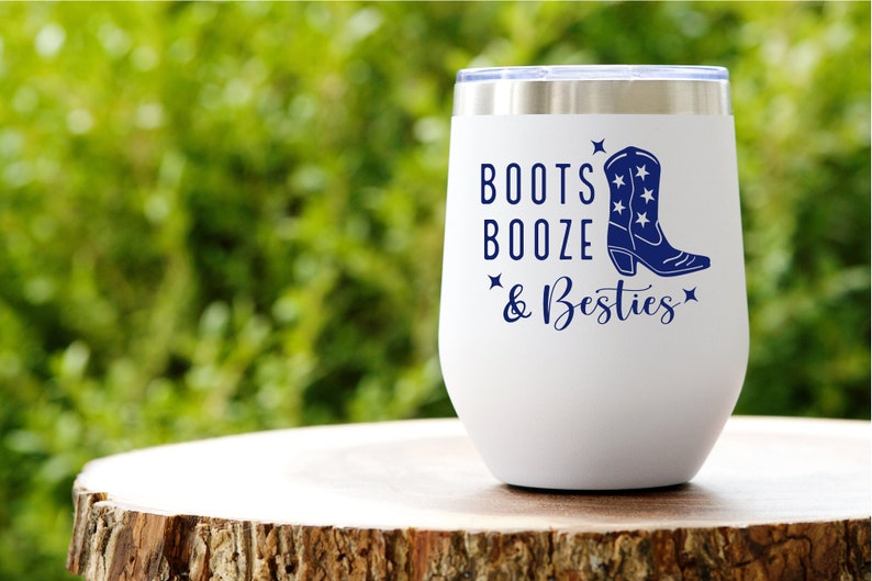 May include: White stainless steel wine tumbler with a blue graphic of a cowboy boot and the text "Boots Booze & Besties".