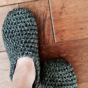 May include: A pair of gray crocheted slippers. The slippers are made with a simple stitch pattern and have a soft, cozy look.
