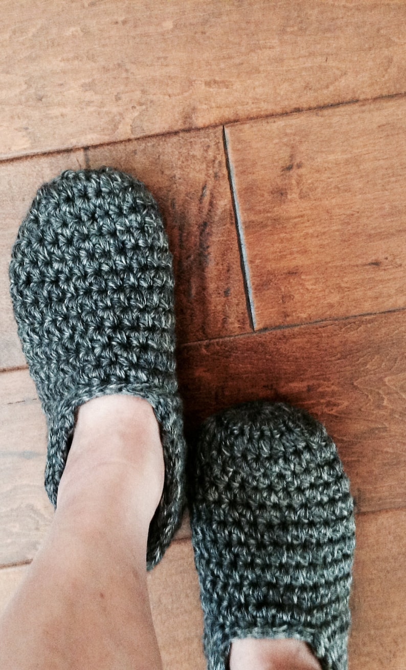 May include: A pair of gray crocheted slippers. The slippers are made with a simple stitch pattern and have a soft, cozy look.