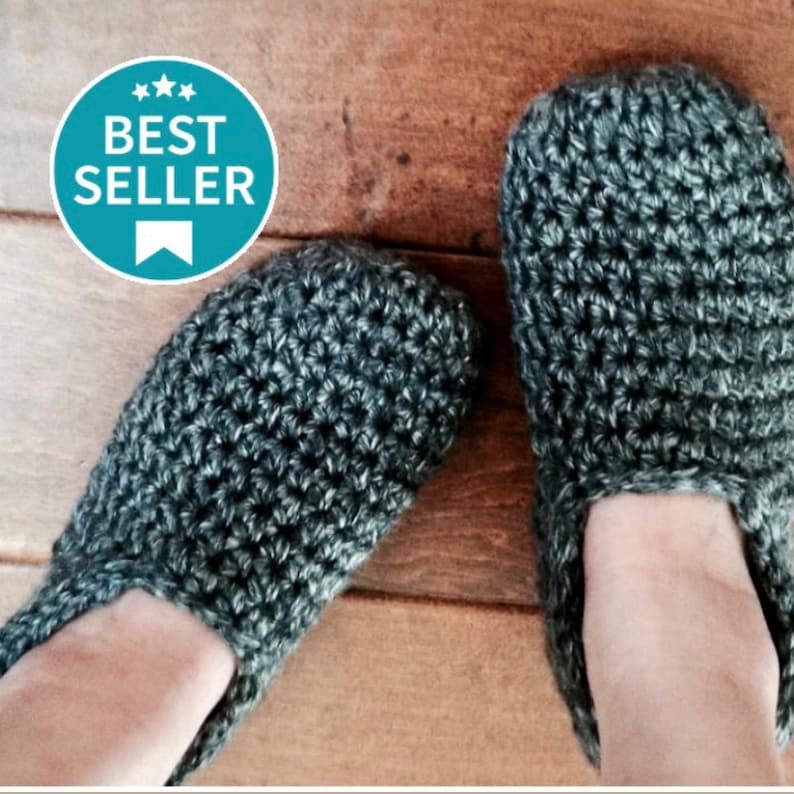 May include: A pair of gray crocheted slippers. The slippers are made with a textured stitch and have a simple, slip-on design.