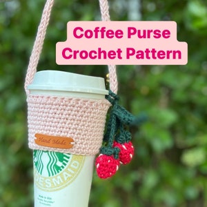 May include: A pink crocheted coffee cup cozy with a brown leather tag that says "Hand Made". The cozy is attached to a long pink crocheted strap with green and red crocheted strawberries hanging from the strap. The text "Coffee Purse Crochet Pattern" is written in pink letters on a white background.