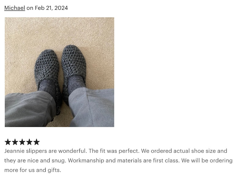 May include: A pair of gray crocheted slippers. The slippers have a textured knit pattern and are worn on a carpeted floor.