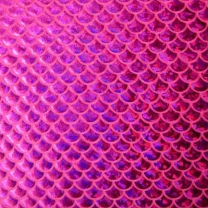 May include: A close-up of a pink and purple mermaid scale pattern. The scales are arranged in neat rows, creating a textured surface. The color transitions from a bright pink to a deeper purple, giving the pattern depth and dimension.